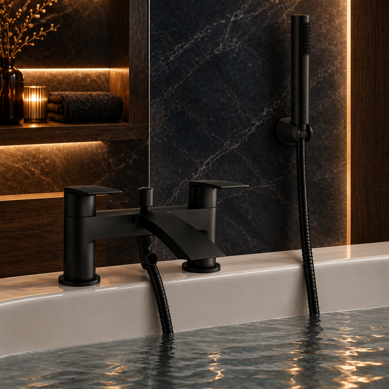 Kartell Nero Curve matt-black bath shower mixer installed on a pale bath with the handheld shower docked in a wall-mounted holder against dark stone tile and wood accents