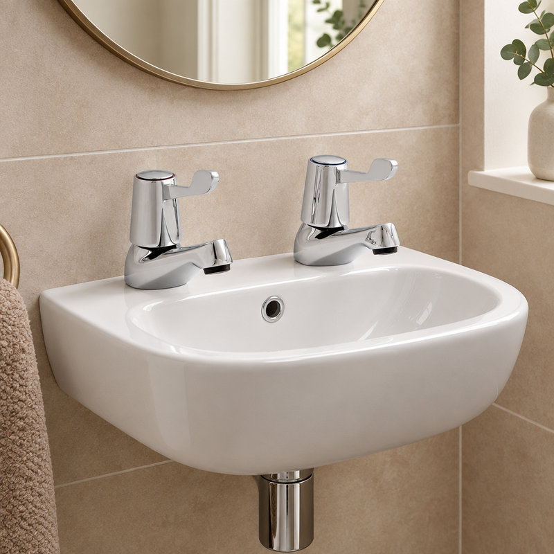 Pair of Kartell Leva polished chrome lever taps fitted to a small cloakroom basin
