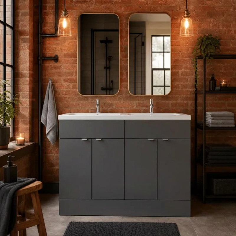 Dark grey double basin vanity in an exposed-brick bathroom with twin mirrors and warm pendant lighting