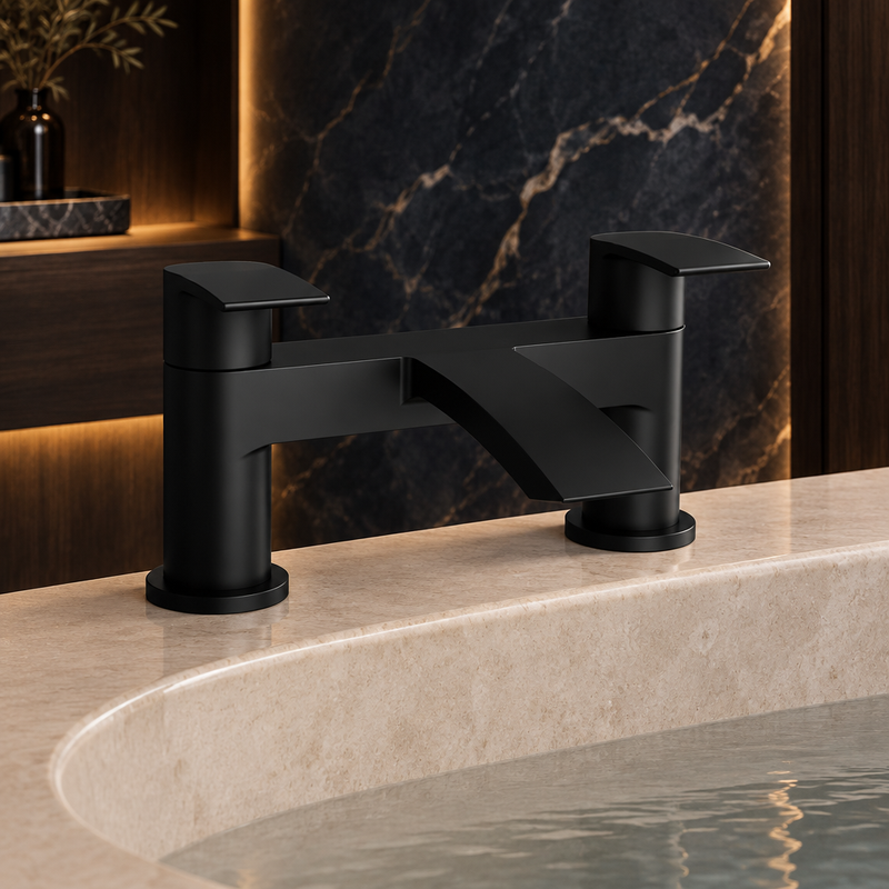 Kartell Nero Curve matt-black bath filler installed on a pale stone bathtub against dark marble and smoked oak with warm lighting
