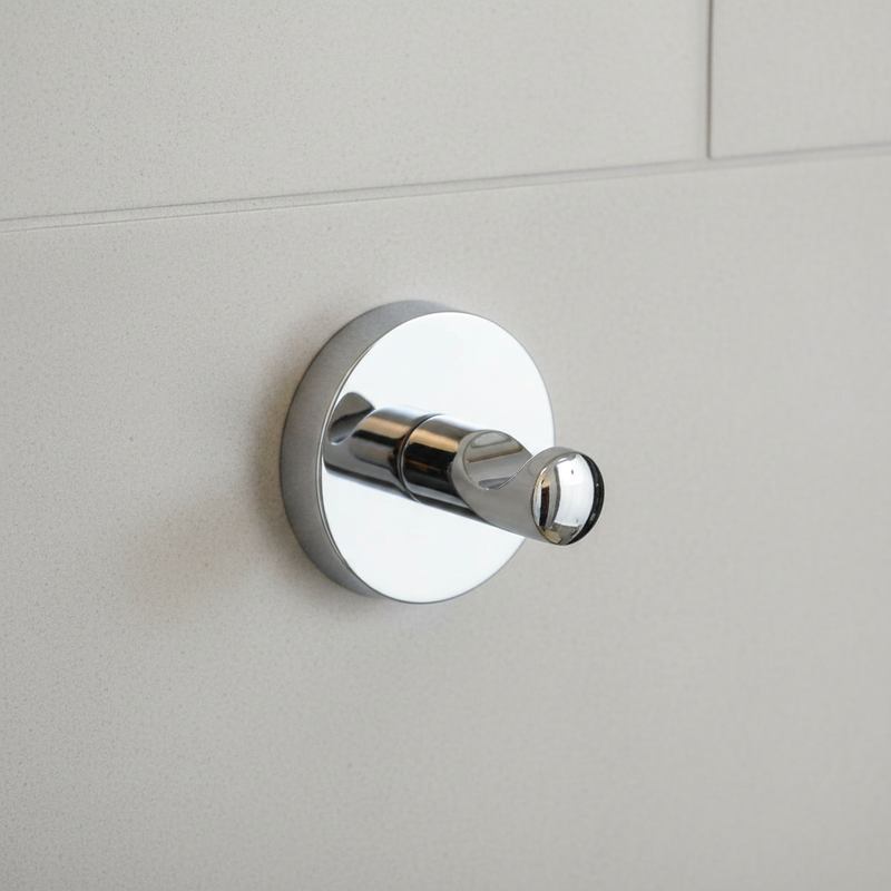 Polished chrome round robe hook mounted empty on bathroom wall