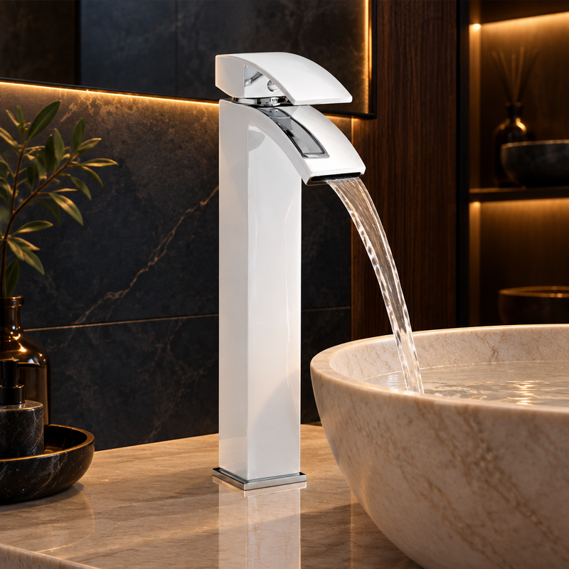 Tall gloss-white basin mixer with chrome accents and waterfall spout installed on a pale basin against dark tile and wood accents