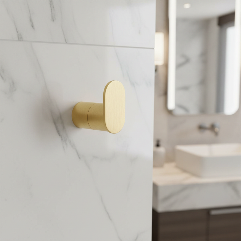 Brushed gold cylindrical robe hook mounted empty on bathroom wall